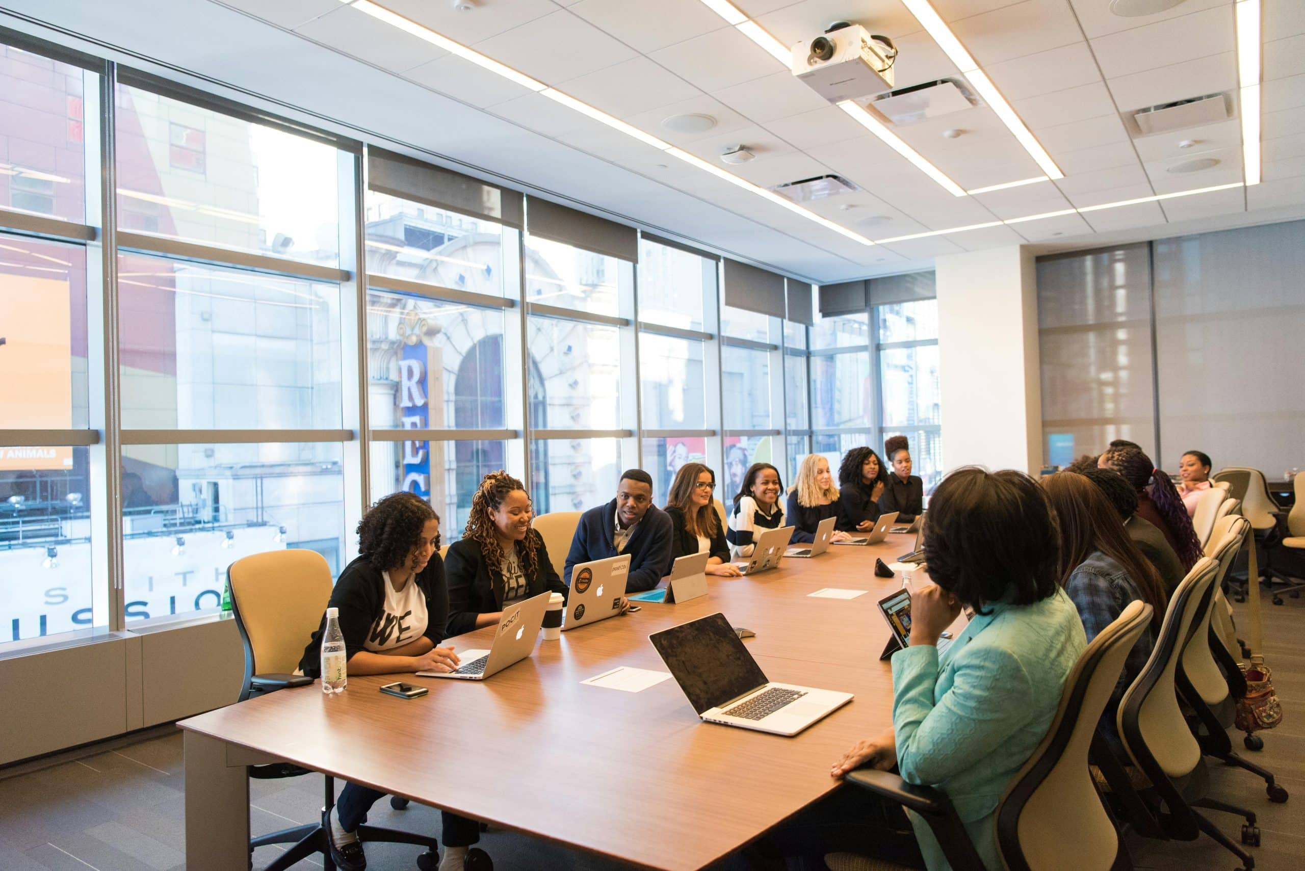 CORPORATE TEAM COLLABORATING WITH LAPTOPS ON THEIR DESKS