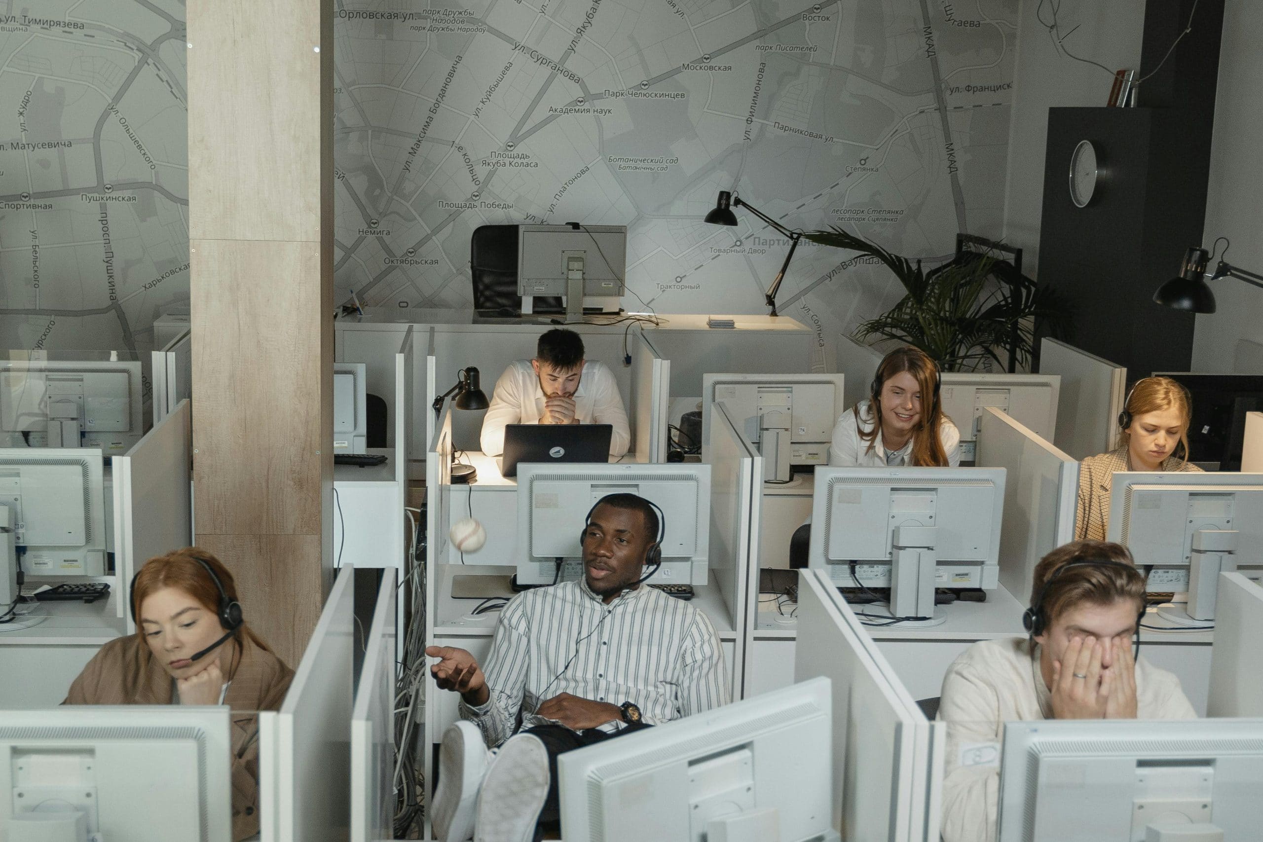 office full of laptops, workers, and desks