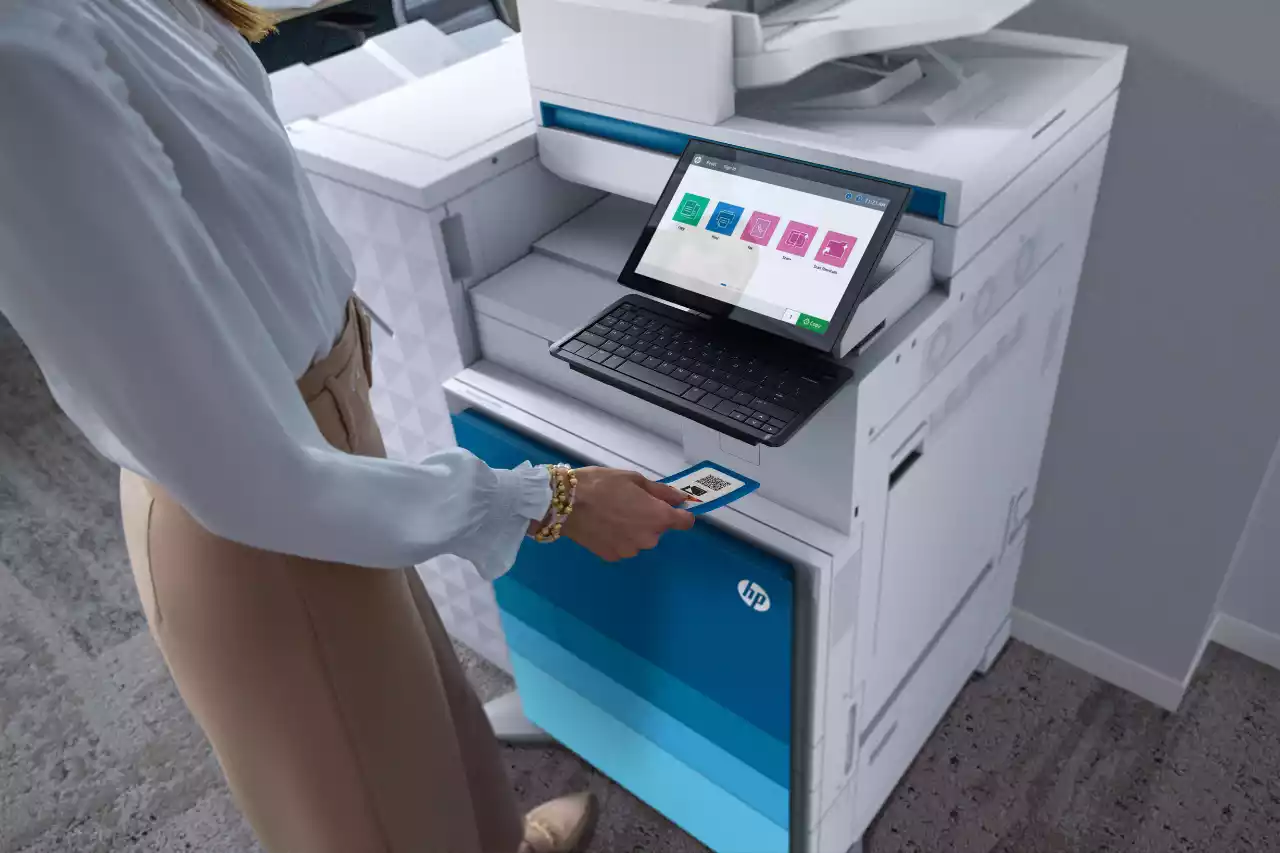 A person using a printer in an office setting.
